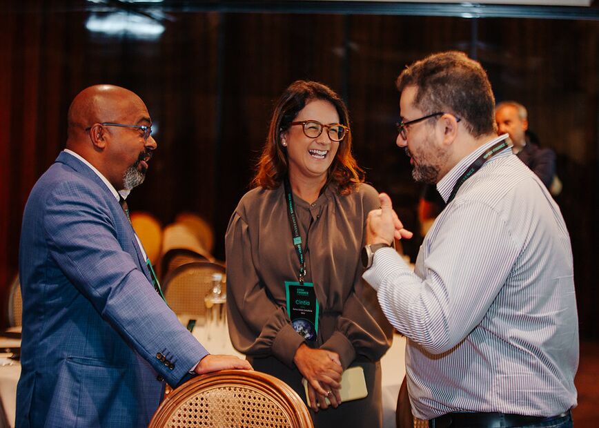 David Ruiz conversando e rindo com duas pessoas no intervalo de um evento.
